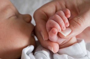 Mom holding newborn's hand