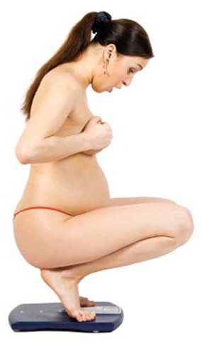 Pregnant woman weighing herself