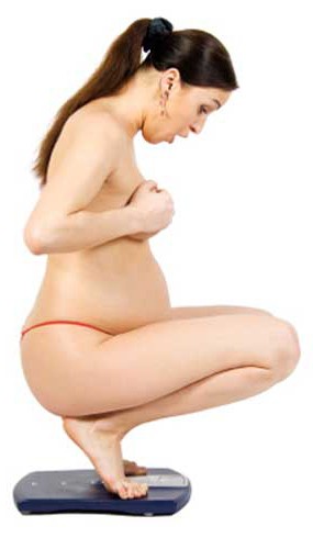 Pregnant woman weighing herself Pregnant woman weighing herself
