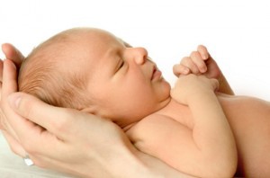 Hands holding newborn