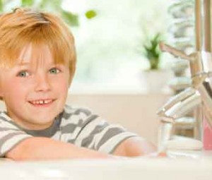 Boy washing hands with soap and water